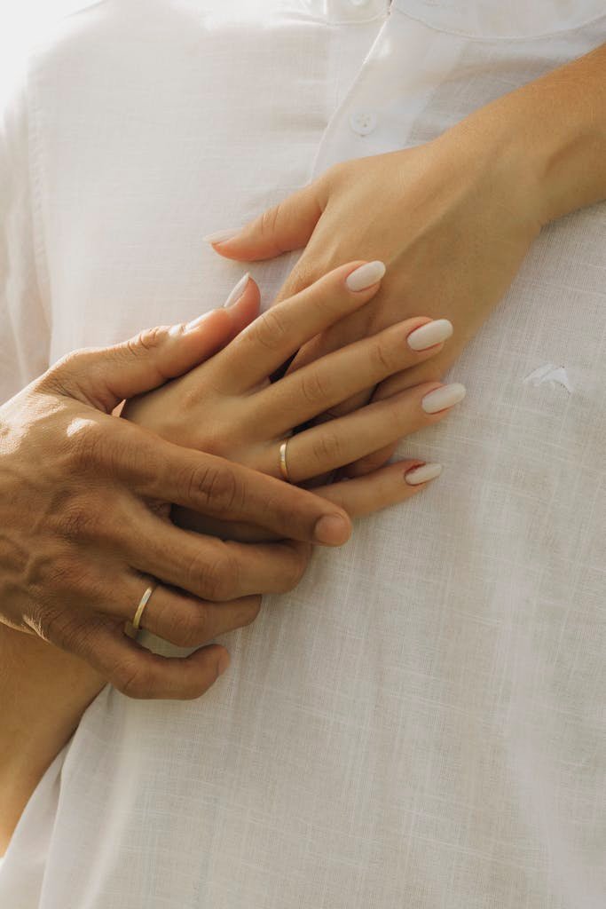 A man and woman holding hands in white